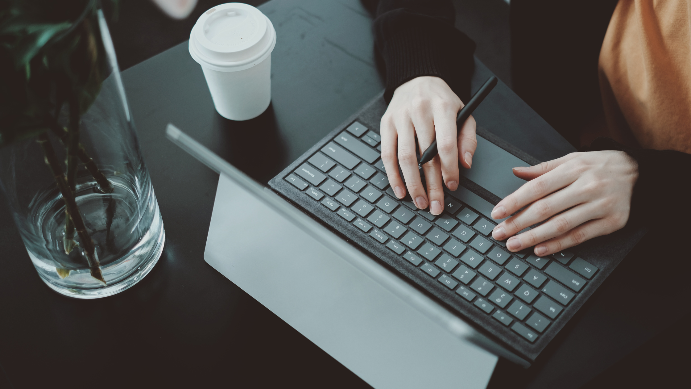 Person working on a laptop with a digital stylus at a desk, representing how to grow your business with smart digital marketing from anywhere.